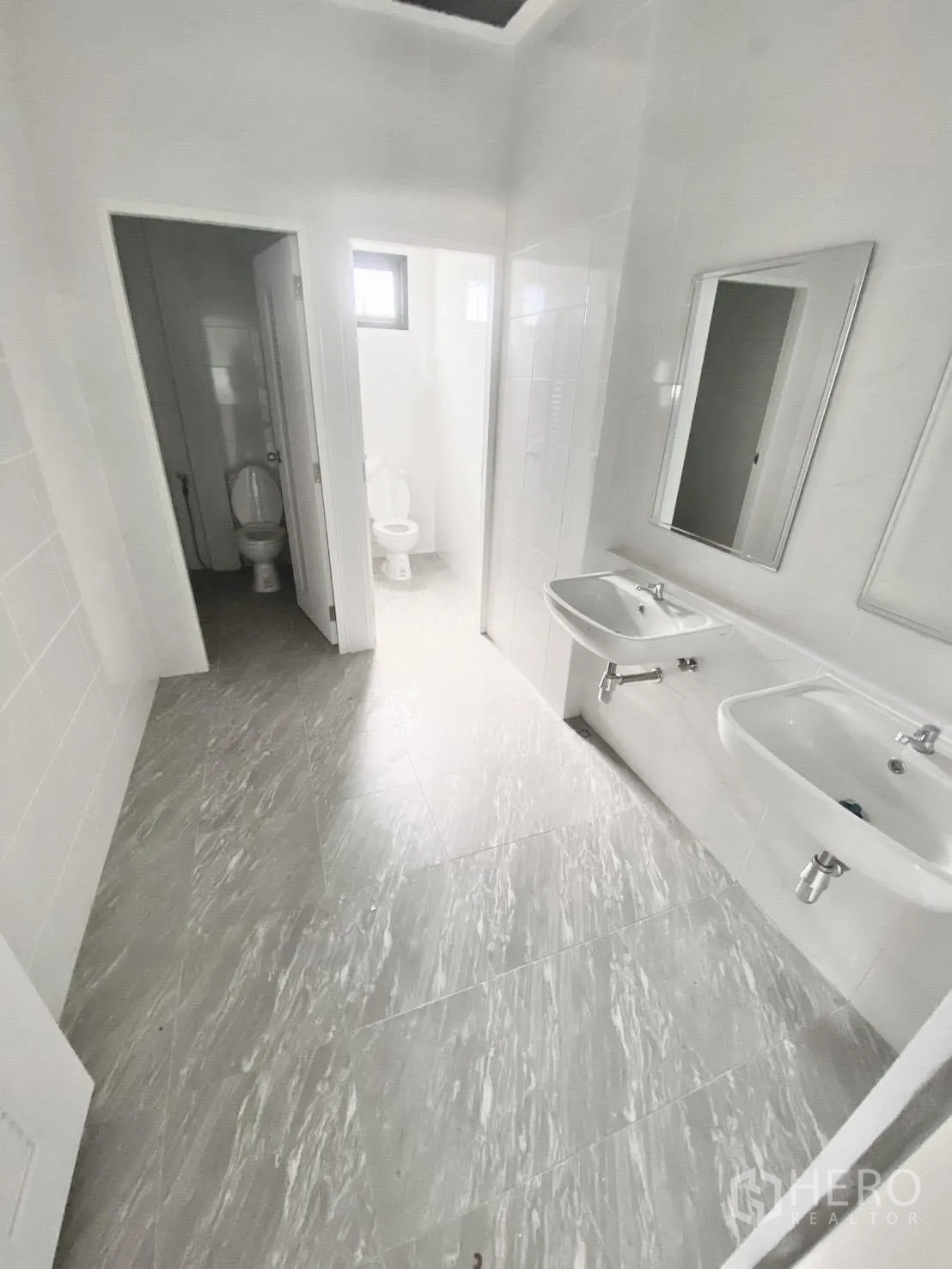Warehouse for rent in Bang Bo, Samut Prakan - Bright restroom with sinks, mirrors, and separate toilet stalls.