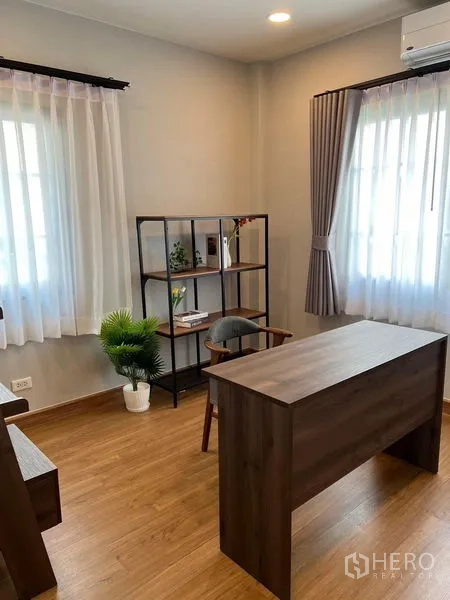 Detached House for rent in Bang Phli, Samut Prakan - Home office with wooden desk, open shelving and light from corner windows.