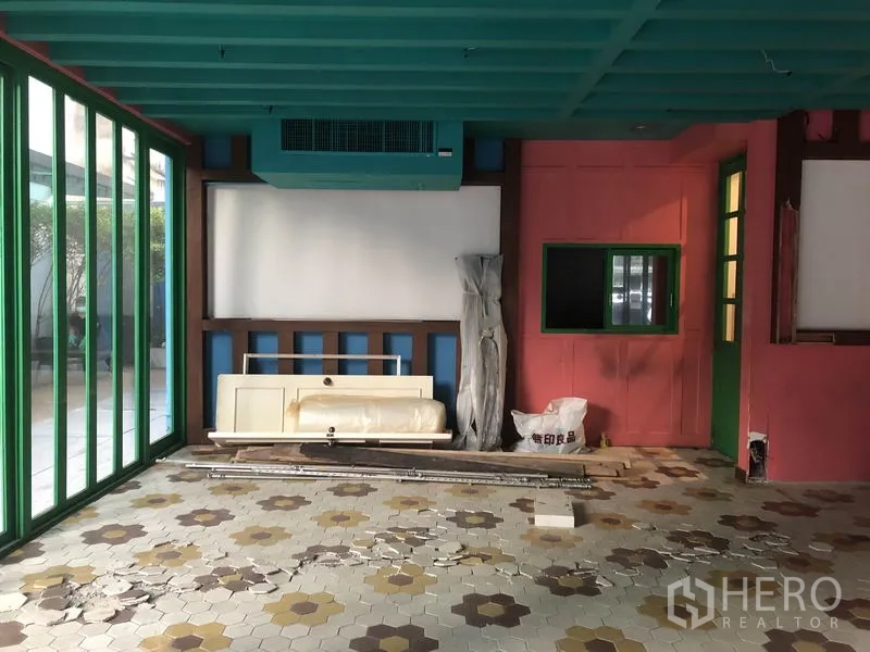 พื้นที่ขายปลีก ให้เช่าในKhlong Toei, Bangkok - พื้นที่หน้าร้านติดถนน ผนังกระจกบานพับกรอบสีเขียว พื้นลายดอกไม้ และเครื่องปรับอากาศเพดาน