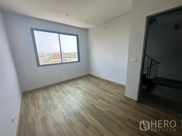 Home Office for rent - Bright bedroom or office with city view through a sliding window and wood floors.