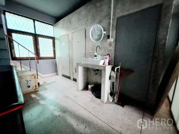 店屋 出租在Bang Rak, Bangkok - 楼梯旁杂物与洗手台区，水泥墙和带栅栏的窗户。