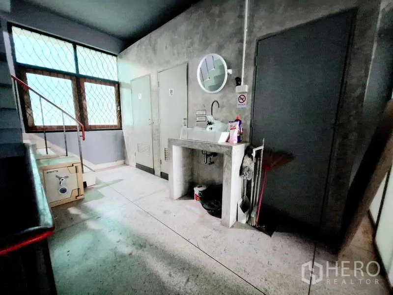 店屋 出租在Bang Rak, Bangkok - 楼梯旁杂物与洗手台区，水泥墙和带栅栏的窗户。