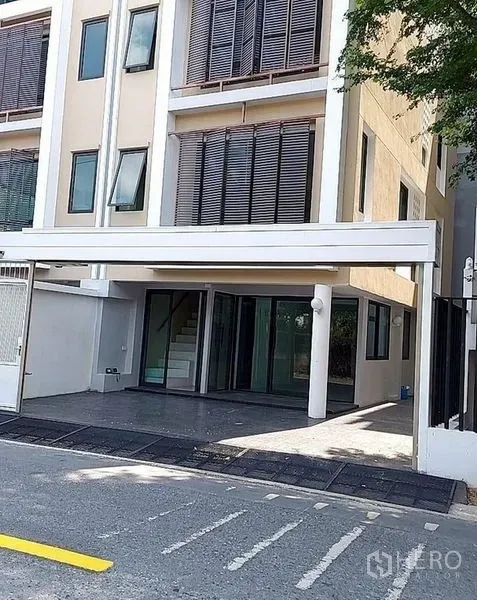 สำนักงานที่บ้าน ให้เช่าในHuai Khwang, Bangkok - มุมมองชั้นล่างของที่จอดรถมีหลังคาและประตูทางเข้ากระจกพร้อมระแนงไม้บังแดด