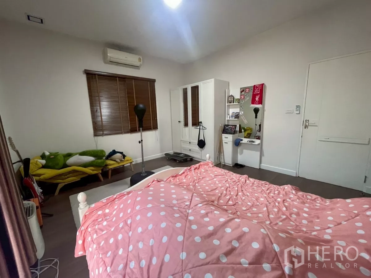 Detached House for sale in Bang Phli, Samut Prakan - Bedroom corner showing bed, closet, air conditioner and seating nook.