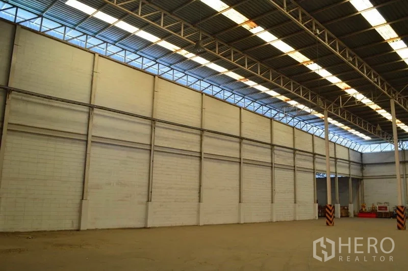 Warehouse for rent in Bang Sue, Bangkok - Tall interior side wall with clerestory windows and metal roof providing natural light in the Bang Sue warehouse.
