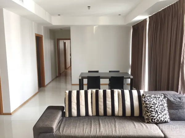 คอนโด ให้เช่าในKhlong Toei, Bangkok - พื้นที่นั่งเล่นกว้างพร้อมโซฟาหมอนลายทาง ชุดโต๊ะอาหาร 4 ที่นั่ง และโถงทางเดินไปยังห้องนอน