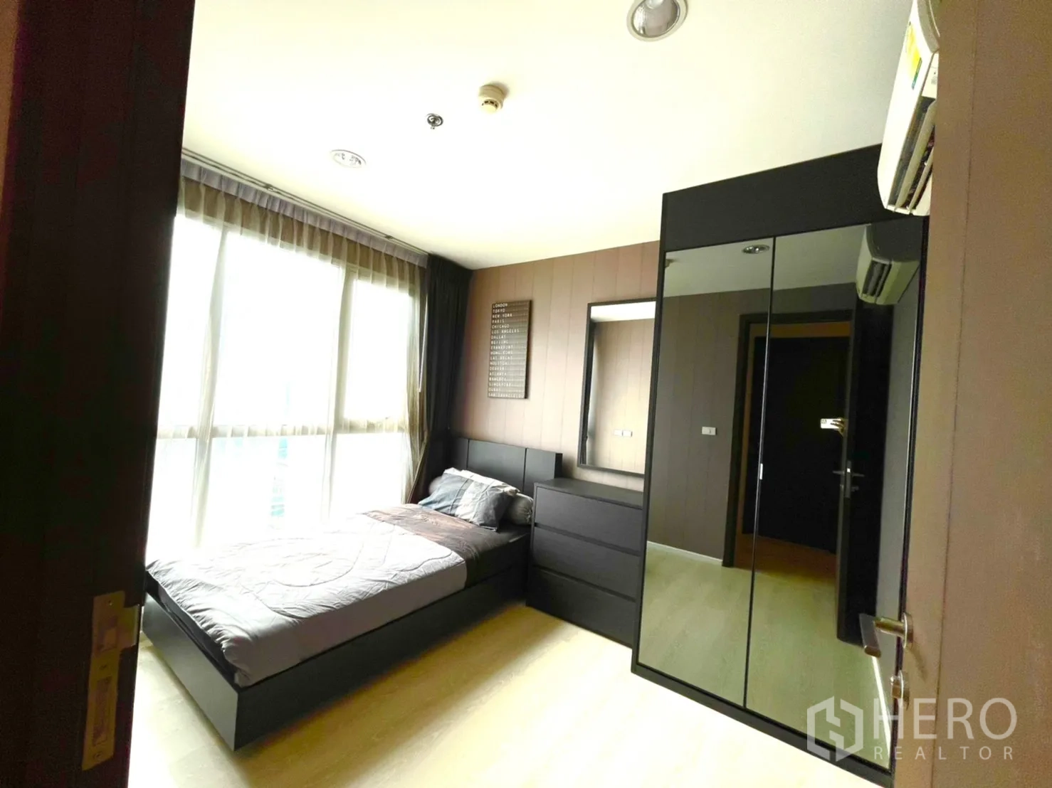 Condominium for sale in Sathon, Bangkok - Second bedroom with single bed, mirrored wardrobe and large bright window.