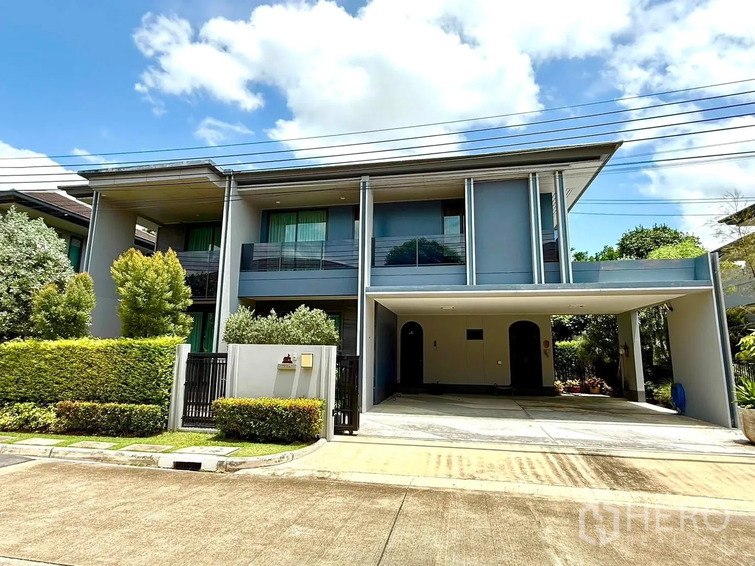 บ้านเดี่ยว for rent in Bang Kapi, Bangkok - ด้านหน้าบ้านสองชั้นสมัยใหม่พร้อมระเบียงและที่จอดรถในร่ม.