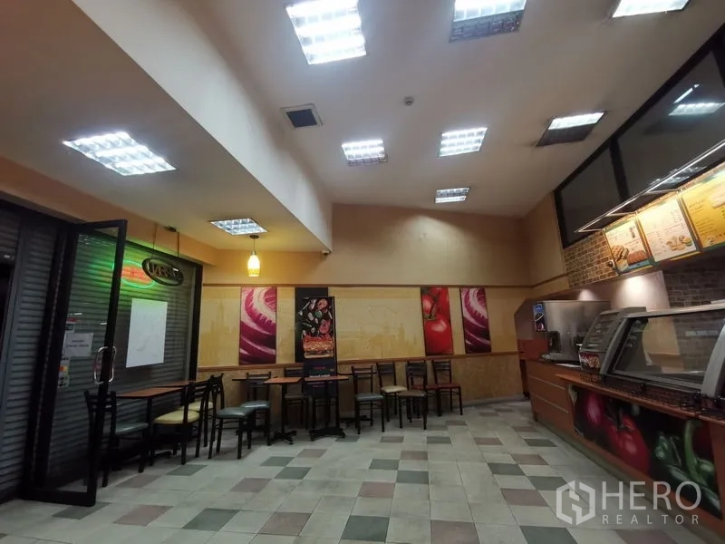 店屋 出租在Bangkok - 就餐区，桌椅与嵌入式照明，旁有玻璃入口。
