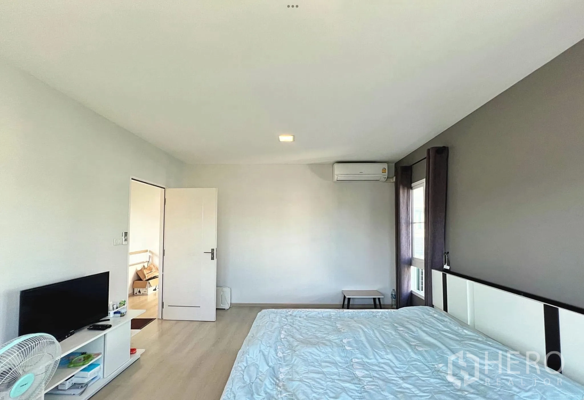 Townhouse for rent or sale in Sai Mai, Bangkok - Spacious master bedroom with air-conditioning and neutral décor.