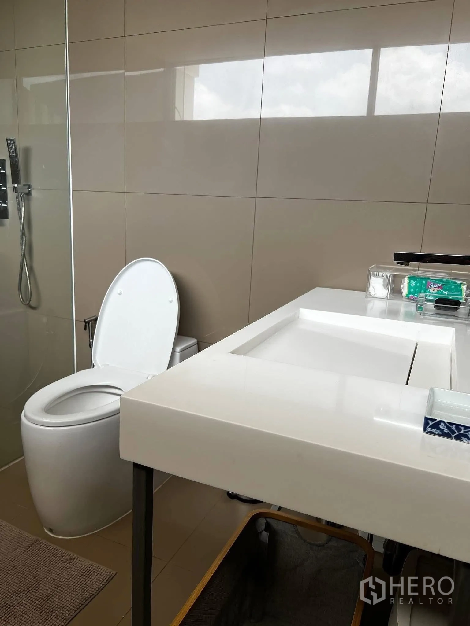 ทาวน์เฮาส์ for rent or sale in Watthana, Bangkok - ห้องน้ำมีเคาน์เตอร์อ่างล้างหน้าสีขาวติดกับตู้กระจกและโถสุขภัณฑ์