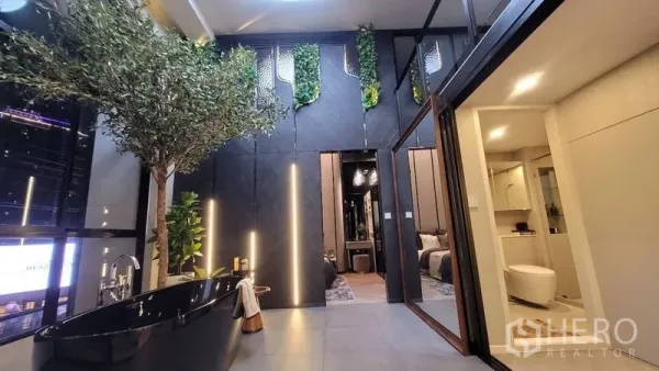 Detached House for sale in Watthana, Bangkok - Indoor courtyard with a black freestanding bathtub, vertical garden wall, and access to a bedroom and bathroom.