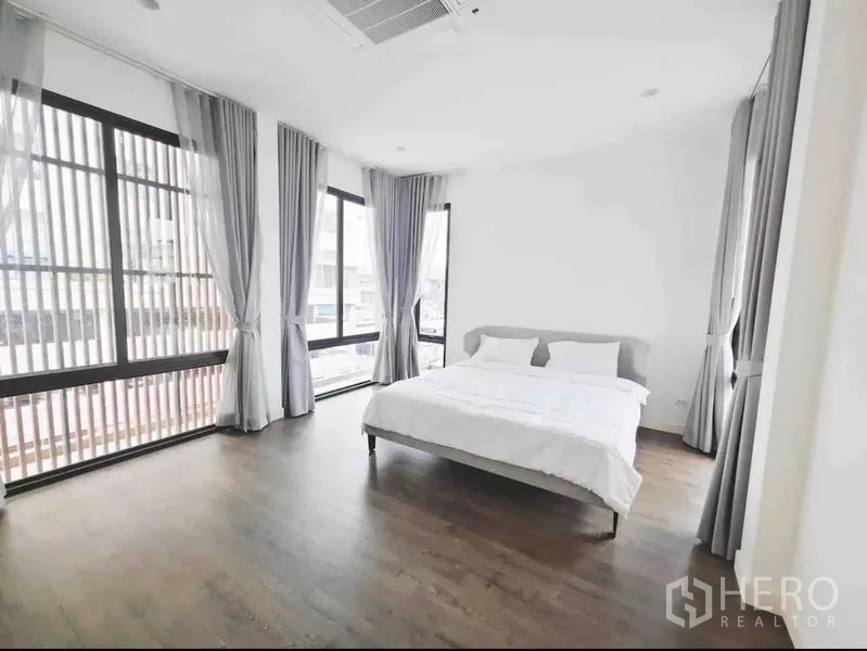 Detached House for rent - Corner bedroom with tall windows and sheer curtains for natural light.