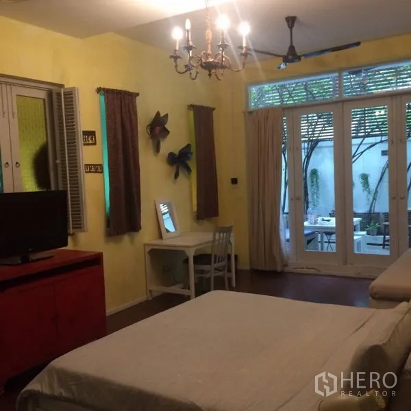 บ้าน ให้เช่าในSathon, Bangkok - ห้องนอนอบอุ่น โคมแชนเดอเลียร์ โต๊ะทำงาน และประตูบานเฟรนช์เปิดสู่คอร์ทยาร์ด