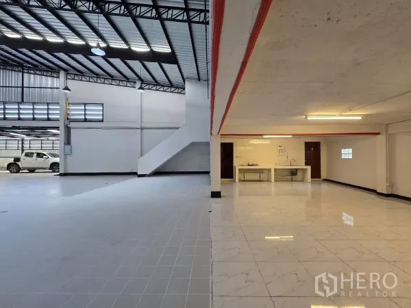 Warehouse for rent in Chatuchak, Bangkok - Ground-floor warehouse area with kitchenette and stair access to office.