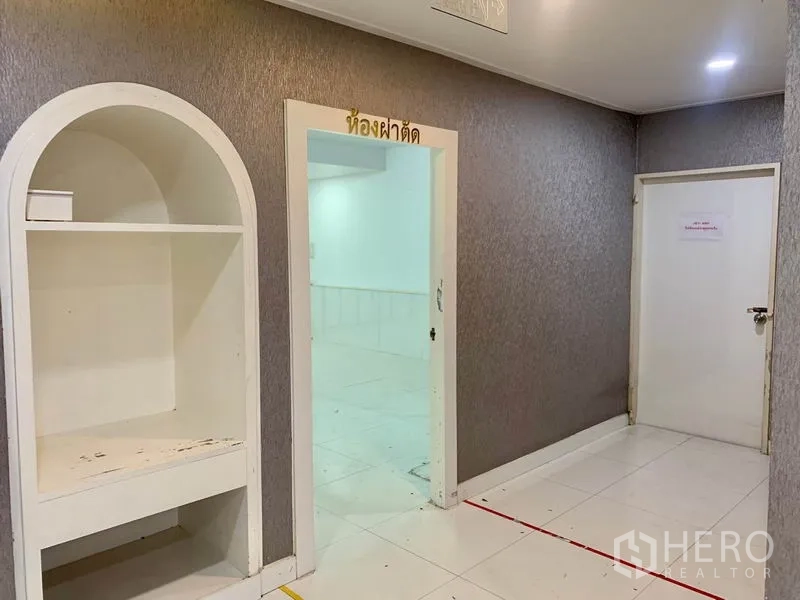 พื้นที่ขายปลีก ให้เช่าในKhlong Toei, Bangkok - โถงทางเดินภายใน มีชั้นบิวท์อินซุ้มโค้ง พื้นกระเบื้องสีขาว และประตูเข้าสู่ห้องทำงานสว่าง