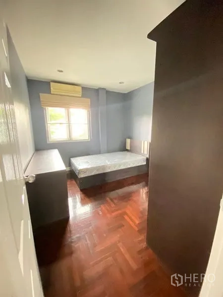 独立式住宅 出租 - 紧凑卧室，带床架、深色衣柜、拼花木地板与窗户。