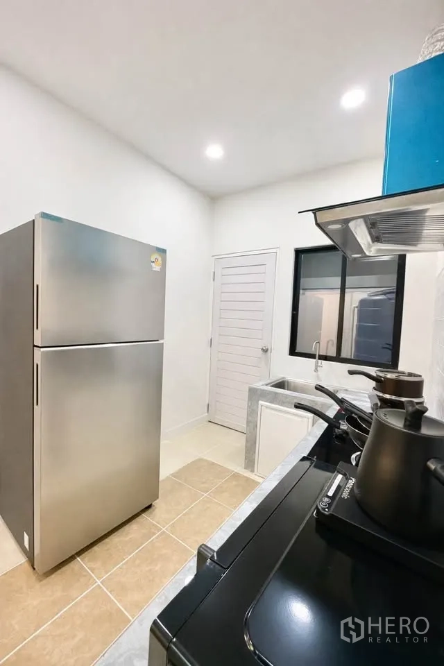 独栋房屋 for rent in Huai Khwang, Bangkok - 厨房另一角度，见冰箱、窗边水槽与灶台。