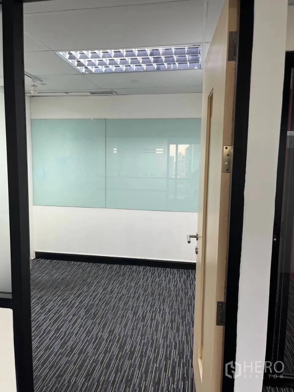 Office Space for rent in Khlong Toei, Bangkok - Small meeting room with a glass wall and striped carpet flooring.