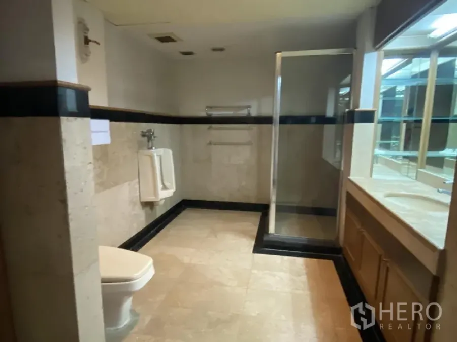 办公空间 出租在Din Daeng, Bangkok - 宽敞的办公卫浴，瓷砖地面，玻璃淋浴房、盥洗台与小便器。