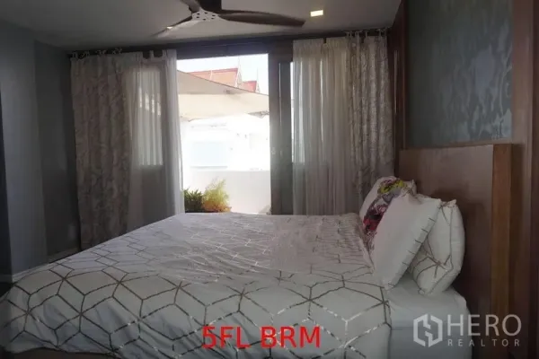 店屋 出售在Phra Khanong, Bangkok - 卧室配大床、吊扇与窗帘，可通向小露台。