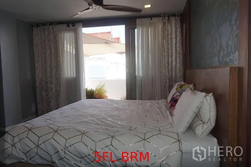 店屋 出售在Phra Khanong, Bangkok - 卧室配大床、吊扇与窗帘，可通向小露台。