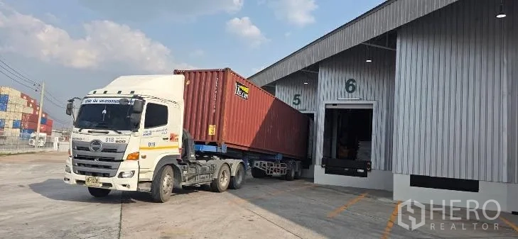 Factory for rent in Si Racha, Chon Buri - Container truck at numbered loading docks outside the warehouse.