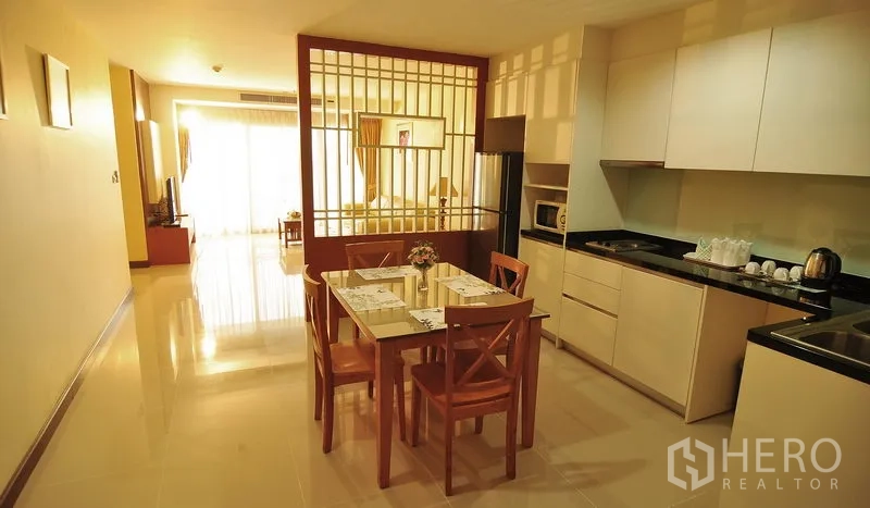 อพาร์ทเมนท์ ให้เช่าในKhlong Toei, Bangkok - ครัวและพื้นที่ทานอาหารแบบเปิด โต๊ะ 4 ที่นั่ง ตู้ครัวเรียบหรู และฉากกั้นดีไซน์ ในคลองเตย