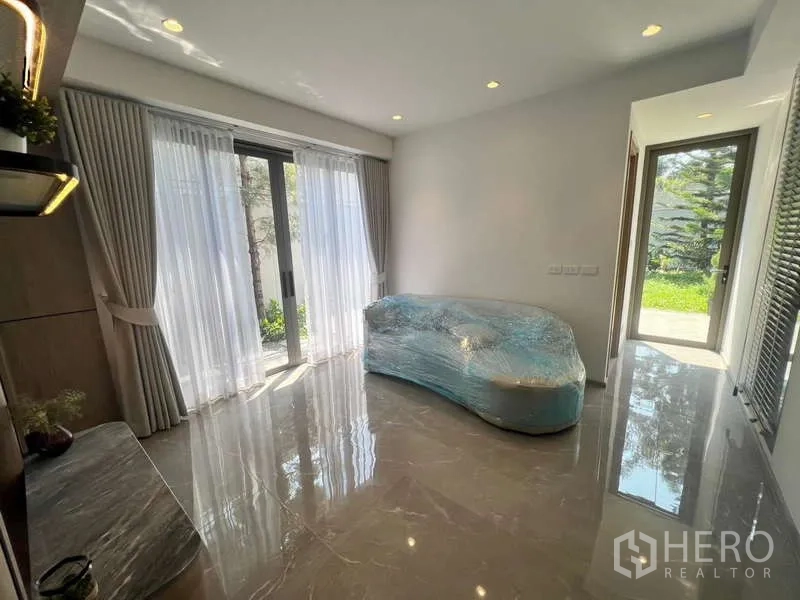 ทาวน์เฮาส์ ให้เช่าในPhra Khanong, Bangkok - ห้องอเนกประสงค์ชั้นล่าง ปูพื้นกระเบื้องเงา มีประตูกระจกสไลด์ออกสู่สวน