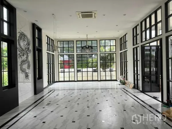 带办公室的家 出租在Bang Na, Bangkok - 挑高大厅，黑框落地窗与大理石地面，并设吊灯。