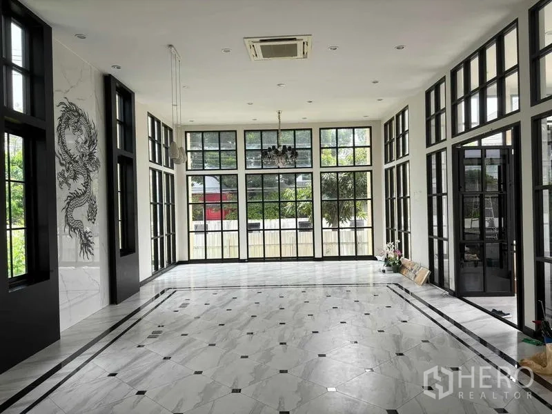 带办公室的家 出租在Bang Na, Bangkok - 挑高大厅，黑框落地窗与大理石地面，并设吊灯。