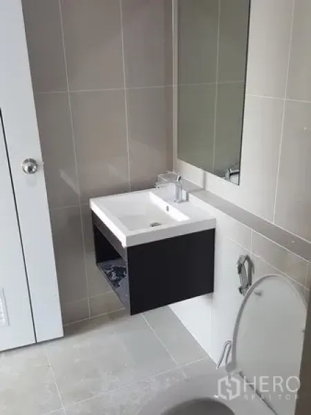 ทาวน์เฮาส์ ให้เช่าในBueng Kum, Bangkok - ห้องน้ำสมัยใหม่พร้อมอ่างล้างหน้าติดผนัง กระจกบานใหญ่ และผนังกระเบื้องโทนกลาง