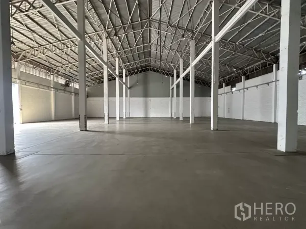 คลังสินค้า ให้เช่าในPhra Khanong, Bangkok - พื้นที่เก็บสินค้ากว้าง พื้นคอนกรีต เสาสีขาว และประตูโรลเลอร์ด้านท้าย