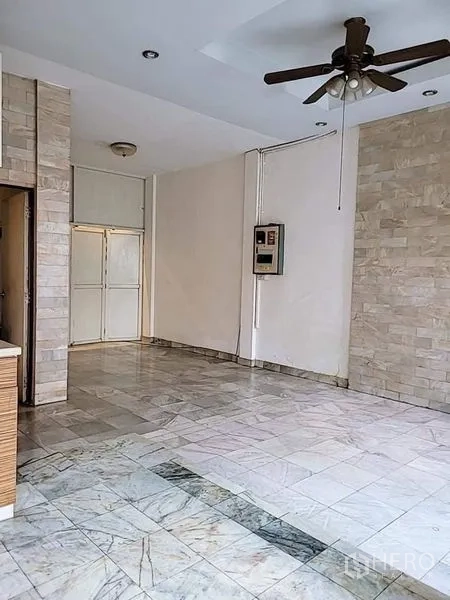 Detached House for rent - Open-plan living area with marble flooring, stone accent wall and a ceiling fan.