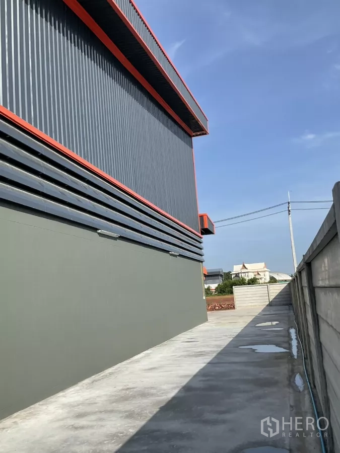 工厂 出售在Samut Sakhon - 远景街道视角，可见围墙内的新建厂房