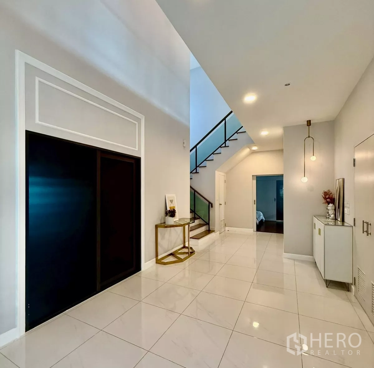 Detached House for rent in Bang Phli, Samut Prakan - Hallway with pendant lighting, tiled floors and stairway to the upper level.