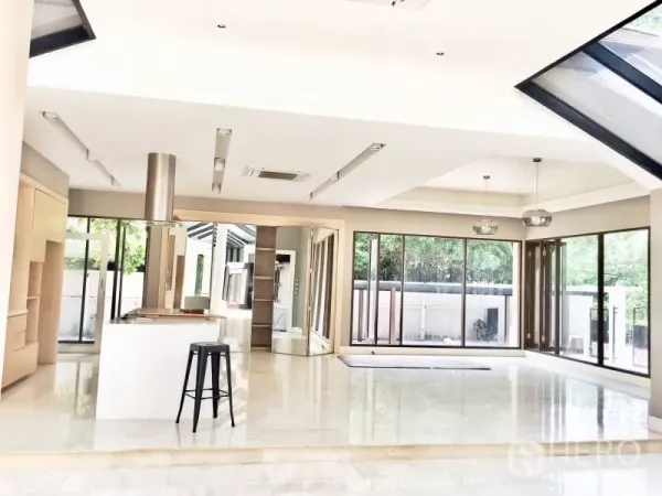 Detached House for rent in Khlong Toei, Bangkok - Open-plan living and dining area with skylights, polished floors and wide sliding glass doors to the patio.