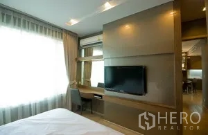 คอนโด ให้เช่าในKhlong Toei, Bangkok - ผนังทีวีติดตั้งพร้อมโต๊ะทำงานในห้องนอน รับแสงธรรมชาติจากหน้าต่างกว้าง