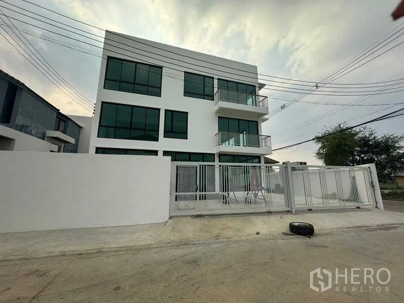 Home Office for rent in Don Mueang, Bangkok - Front elevation of a white three-storey building with perimeter wall and sliding gate.