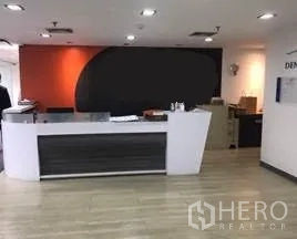 办公空间 出租在Khlong Toei, Bangkok - 现代接待前台，白色台面与橙色强调墙面。