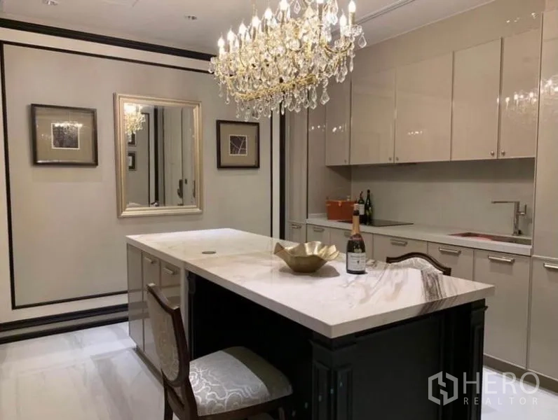 คอนโด ให้เช่าในKhlong Toei, Bangkok - ภาพกว้างของห้องครัว ตู้เงาเรียบ เกาะครัวหินอ่อน กรอบรูป และโคมระย้าระยิบระยับ