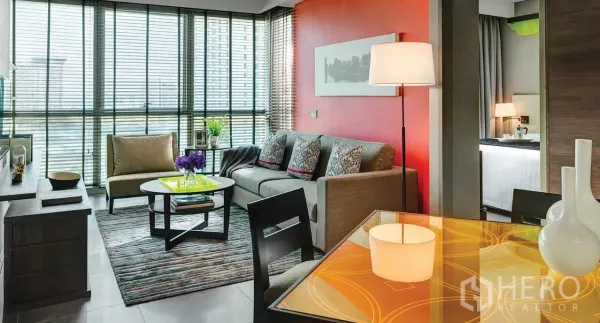 อพาร์ทเมนท์ ให้เช่าในKhlong San, Bangkok - ห้องนั่งเล่นสว่างโปร่ง ผนังกั้นกระจกเต็มบาน ผนังสีแดง และโซฟาสมัยใหม่ในย่านคลองสาน