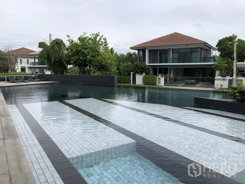 Detached House for rent in Bang Kapi, Bangkok - Resort-style communal swimming pool with sun loungers inside the gated estate.