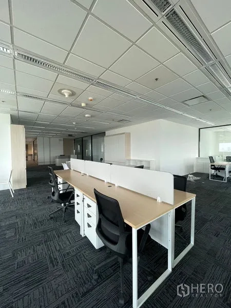 Office Space for rent in Dusit, Bangkok - Long row of desks with partitions in a bright open-plan office.