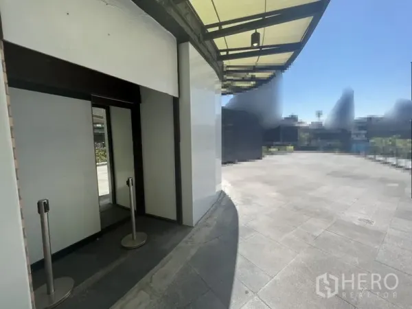 零售空间 出租在Watthana, Bangkok - 角落店面外立面，宽大雨棚与开放式广场，位于通罗商圈曼谷瓦他那区。