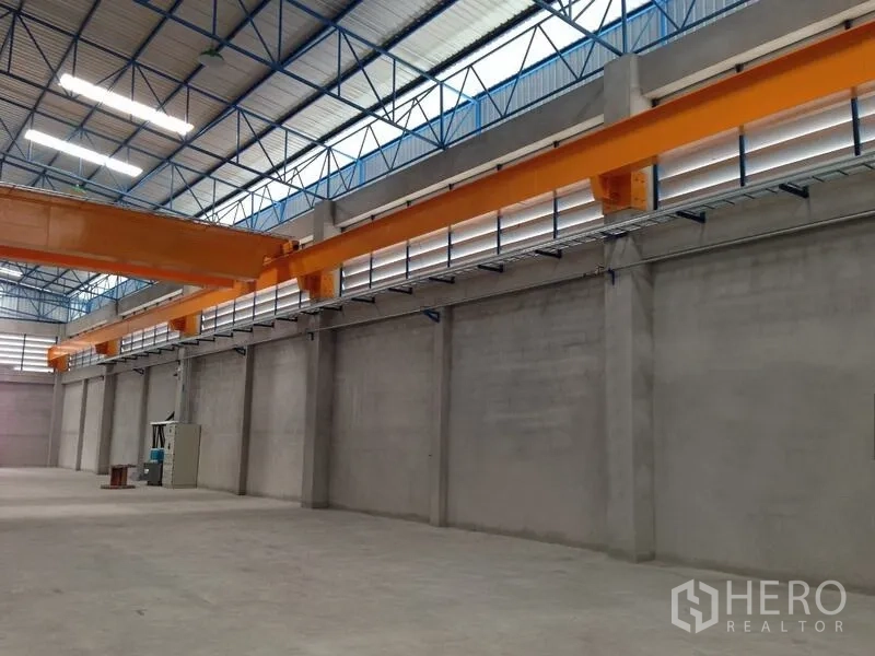 คลังสินค้า ให้เช่าในMueang Samut Prakan, Samut Prakan - ระยะใกล้ของรางเครนตามผนังคอนกรีต พร้อมช่องลมบานเกล็ดและอุปกรณ์ไฟฟ้า