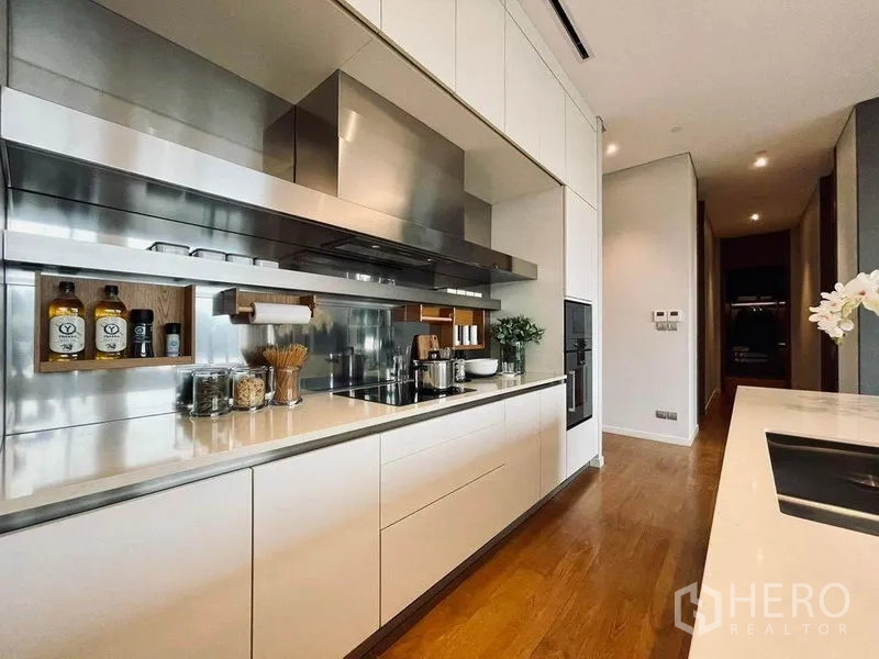 คอนโด ขายในPathum Wan, Bangkok - ห้องครัวสไตล์โมเดิร์น ตู้สีขาว แผงสแตนเลส และเคาน์เตอร์หินยาวในคอนโดหรู
