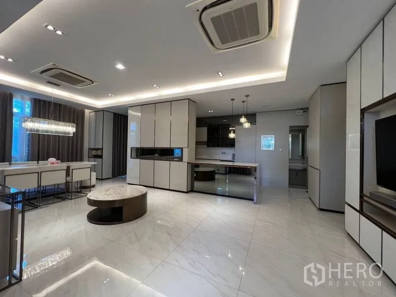 Detached House for rent or sale in Bang Phli, Samut Prakan - Open-plan living and dining area with marble floors, built-in cabinetry and recessed lighting.