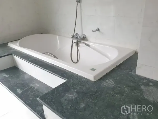 Condominium for rent in Watthana, Bangkok - Bathroom with large built-in bathtub, handheld shower, and marble counters.