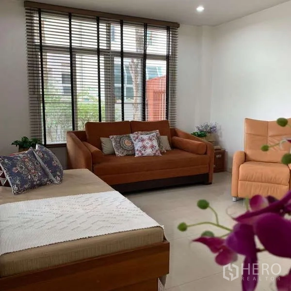 独立式住宅 出租在Lat Krabang, Bangkok - 家庭活动室，大窗户与橙色沙发椅。